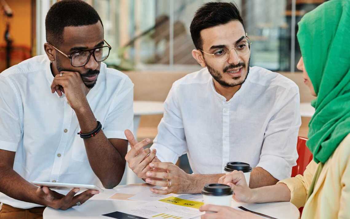 Small diverse group of people talk around a table